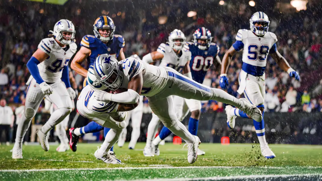Linebacker wrapping a tackle behind the line of scrimmage in rain mist