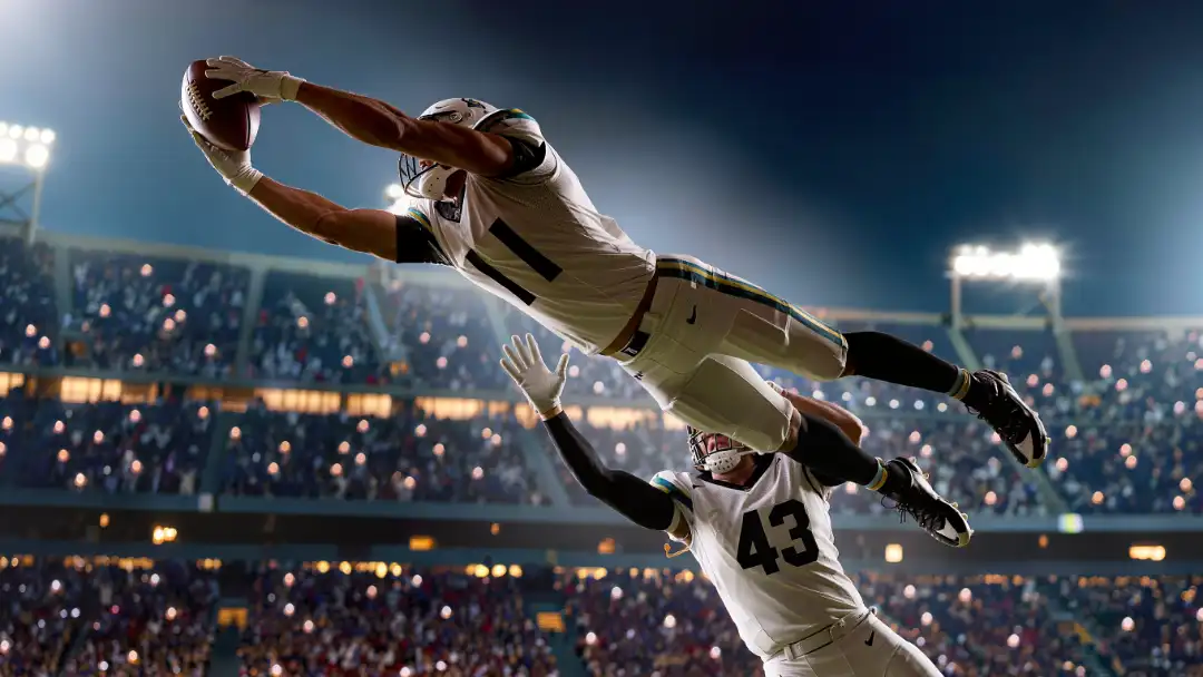 Wide receiver fully extended hauling in a long pass over a defender
