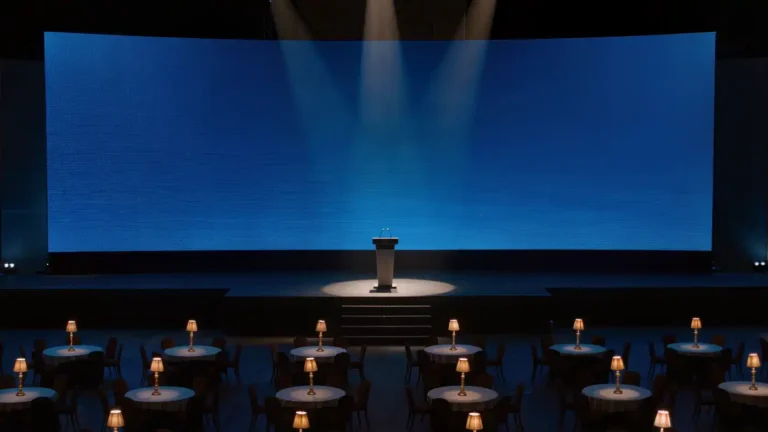 Empty draft-night stage with podium under a spotlight and blue LED board