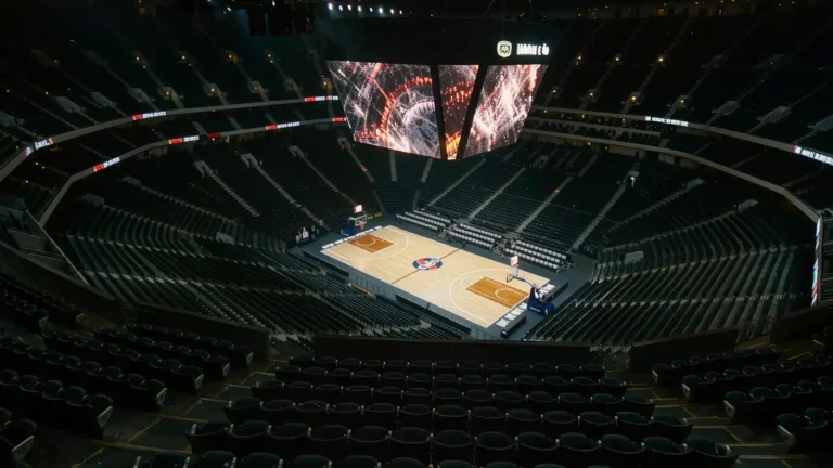 Overhead view of an empty NBA court with glowing jumbotron above