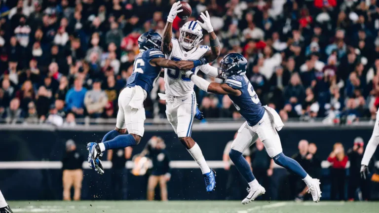 Slot receiver making a contested catch over the middle between two defenders