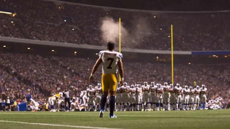 Rookie quarterback walking onto a packed NFL field at night with breath steaming