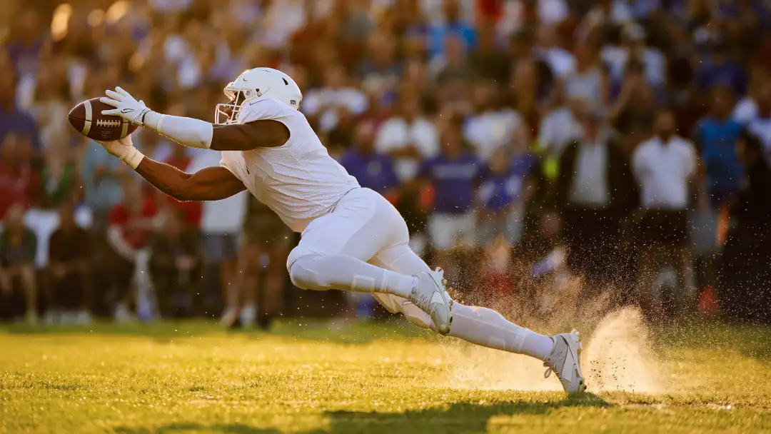 Receiver looking over his shoulder tracking a deep ball at full sprint
