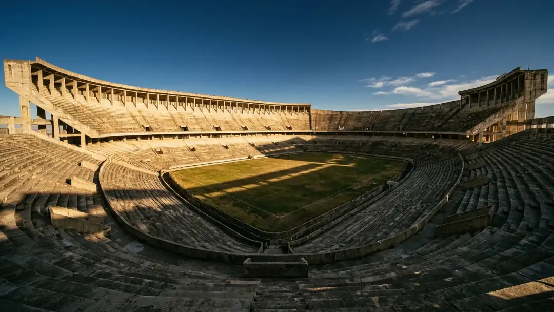 Sun-drenched monumental concrete stadium bowl under a blue sky