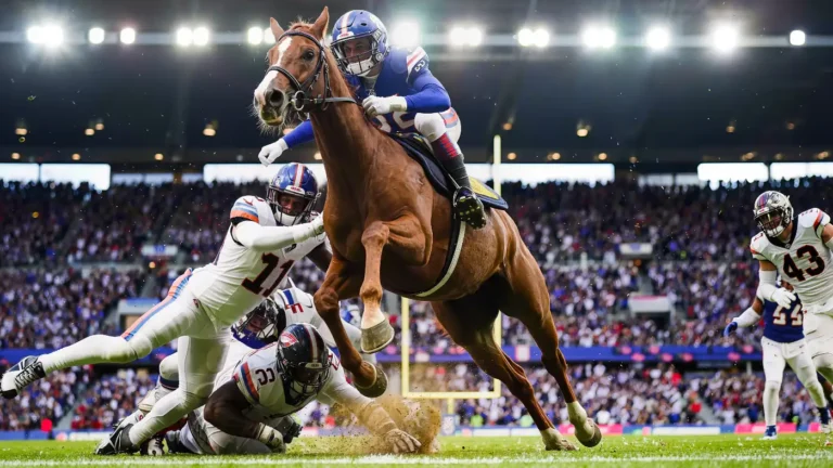 Running back hurdling over a pile of tacklers at the goal line